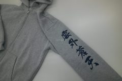 パーカーの左袖に「雲外蒼天」と筆文字で大きめに刺繍した制作事例。糸の色は黒糸。
