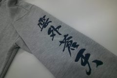 パーカーの左袖に筆文字で大きめに刺繍した制作事例のアップ。