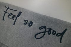 アッシュグレーのパーカーにカジュアルな英字で軽めの3D刺繍を加工した制作事例のアップ。