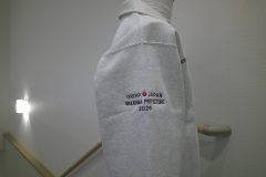 ハーフジップスウェットの右袖にレスキューチームの運営団体のロゴを刺繍した制作事例。