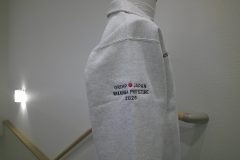 ハーフジップスウェットの右袖にレスキューチームの運営団体のロゴを刺繍した制作事例。