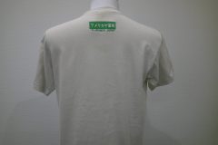 お持ち込みのTシャツの背面衿下に緑糸でボックスロゴを刺繍。その下には地域名を文字刺繍した制作事例。