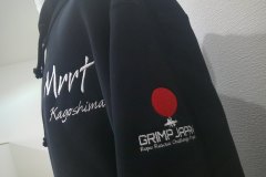 黒のパーカー左袖にレスキューチームの大会運営のロゴデザインを刺繍した制作事例。