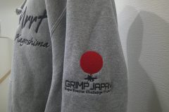 アッシュグレーのパーカー左袖にレスキューチームの大会運営のロゴデザインを刺繍した制作事例。