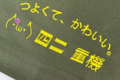 ドライポロシャツの左袖口に、黄色の糸で文字を刺繍した制作事例。可愛らしい顔文字がアクセントになった作品。