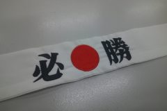 白のハチマキに黒糸で「必勝」と刺繍。文字間に日の丸を赤糸で刺繍した制作事例。