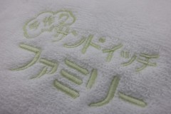 白地のハンドタオルにオリジナルロゴをパステルカラーの黄緑色の糸で刺繍したししゅう屋HONESTの制作事例。