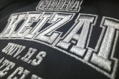 黒のスポーツリュックにオリジナルのチームロゴ刺繡を加工した制作事例の右サイドからのアップ
