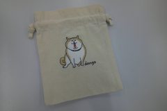 生成りの巾着袋に柴犬をモチーフにしたオリジナル刺繡を加工した制作事例。