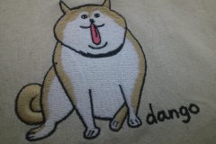 生成りの巾着袋に柴犬をモチーフにしたオリジナル刺繡を加工した制作事例のアップ。