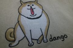 生成りの巾着袋に柴犬をモチーフにしたオリジナル刺繡を加工した制作事例のアップ。