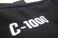 持ち込みのバッグのポケット部分に白糸で「C-1000」と太めのインパクト書体で刺繍をした制作事例の刺繍部分のアップ。