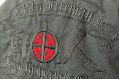 黒のスウィングトップの背面に黒糸と赤糸でツーリングチームのロゴをビッグサイズ刺繍にて制作した、刺繍屋HONESTの制作実績。斜めアングルからの刺繍部分のアップ。
