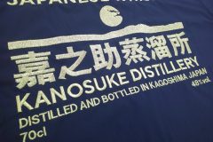 黒のポロシャツ背面に、金色の糸でウイスキーのブランド名や蒸溜所の情報が大きく刺繍されている制作事例のアップ。