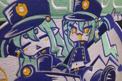 黒いジャケットの背中に、カラフルな列車とキャラクターの大きな刺繍が入った制作事例のキャラクター部分のアップ。