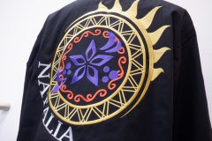 黒のジャケット背面に複数の鮮やかな糸色でオリジナルロゴを刺繡した制作事例のアップ。