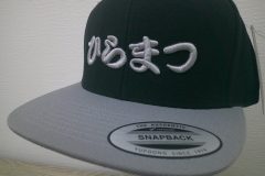 ベースボールキャップ前面にシルバーグレーの糸で社名ロゴを3D刺繍で加工したオリジナルキャップ刺繍の制作実績のアップ。