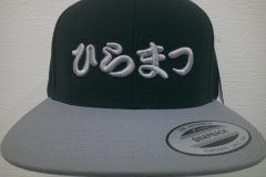 ベースボールキャップ前面にシルバーグレーの糸で社名ロゴを3D刺繍で加工したオリジナルキャップ刺繍の制作実績。