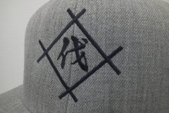 アッシュグレーの帽子に黒糸でシンプルな社名ロゴを加工した、オリジナル刺繍の制作実績のアップ。