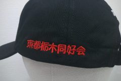 お持ち込みの帽子の左側面に赤糸で同好会名のシンプルに刺繍した制作実績。