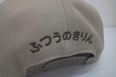 コットンキャップ背面に茶色の糸で文字を刺繍。書体は丸ゴシック体を使用した加工事例。