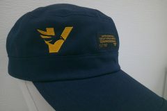 紺の帽子の右前面にVとイーグルが合体したようなロゴをオレンジの糸で刺繍した制作事例のアップ。