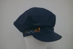 お持ち込みのキャスケットの右前面に白とオレンジの糸でシンプルに企業ロゴを刺繍した制作実例。
