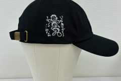 黒のコットンキャップの右サイドに白糸で手描きの線画で家族のイラストを刺繍した制作事例。