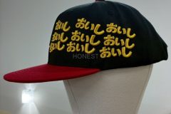 ベースボールキャップの左前面に金糸で文字を27文字も縫った、3D刺繍の制作事例。