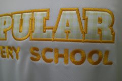 白いTシャツにギンガムチェック柄の生地で英文字をカットし縁取り刺繡した制作事例のアップ。