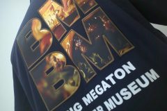 黒のTシャツにハンバーガー画像のプリント生地を英文字で切り抜いた生地を縁取り刺繡した加工見本のアップ。