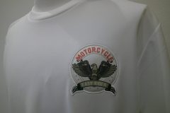 白いTシャツの左胸にクラシックなアメリカンバイク風のイラスト生地を縁取り刺繡した制作事例。