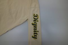 長袖Tシャツの左袖にロングタイプの縁取り刺繍を加工。黒のサテン生地に金糸で加工。