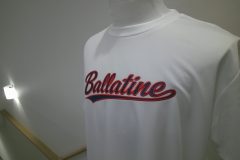 白のドライTシャツの胸中央に「Ballatine」とチーム名を縁取り刺繍した作品。右からのアングル。生地は濃紺、フチ縫いは赤糸で製作。