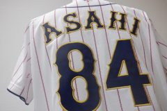 野球ユニフォーム背面に個人名と背番号を金糸で縁取り刺繍した制作実績のアップ。生地は濃紺のエンブクロスを使用。