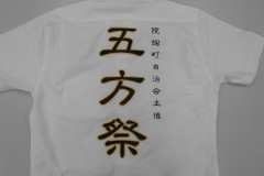 白の濃口シャツの背中に「五方祭」と加工。黒の部分はサテン生地を使用。その生地を金糸で縁取り刺繍した制作事例。