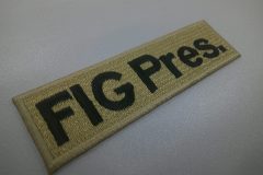 ベージュのエンブクロス生地に黒糸でプレス名を刺繍した、シンプルな文字ワッペン。