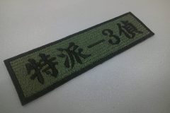 アーミーグリーンの生地に黒文字で刺繍をした、文字ワッペンの制作事例。書体は楷書体。