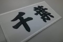 白のツイル生地に黒糸で「千葉」と太めに刺繍した文字ワッペンの制作事例。