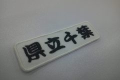 白のツイル生地に黒糸で校名を刺繍した制作実績。