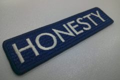 ポリエステルエンブロンのネイビーに白糸でシンプルに会社名を刺繍した長方形の文字ワッペン。