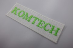 明るめの蛍光グリーンの糸で企業名を刺繍した、長方形の文字ワッペン。
