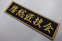 黒の生地にメタリック金糸で釣りのサークル名を刺繍した、煌びやかな文字ワッペンの加工実績。