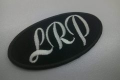 黒生地に白糸でLRPと刺繍。特徴的な筆文字書体で加工した文字ワッペン。