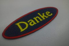 黄色の糸でDankeと刺繍。外周フチはレッドカラーで鮮烈な印象となった文字ワッペンの加工事例。