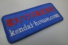 ブルーの生地に上段は赤糸で会社名。下段には会社のURLを白糸で刺繍した、社名の文字ワッペンを制作。