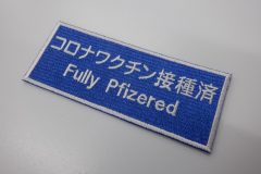 青生地をベースにワクチン接種済みであるメッセージを刺繍した、文字ワッペンの制作事例。