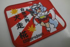 日章旗のグラフィックを背景に、同人キャラクターデザインを存在感抜群に加工したプリントワッペンの加工事例。