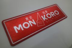 赤地に『MON KORO』の文字とヘラのモチーフが描かれた飲食店のオリジナルプリントワッペンの制作事例。