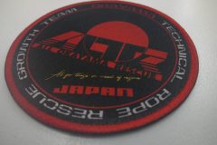 黒地に赤い縁取りの円形のオリジナルプリントワッペンの制作事例。中央に“ALTZ”のロゴと“OKAYAMA RYUJIN”の文字があり、外周に救助チーム名が白文字で入っている。